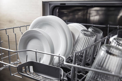 Front view of open automatic stainless fully integrated dishwasher range machine with clean utensils