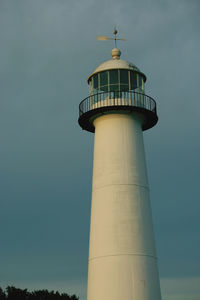 Lighthouse by sea against sky