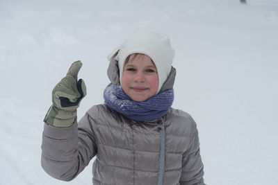 Portrait of smiling woman standing in snow