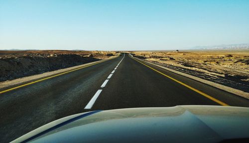 Car on road against clear blue sky