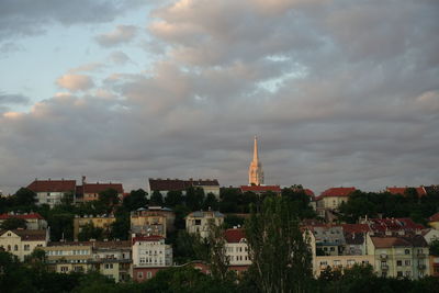 Buildings in city against cloudy sky