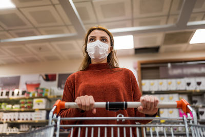 Low angle view of woman wearing mask at shopping mall