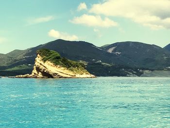 Scenic view of sea and mountains against sky