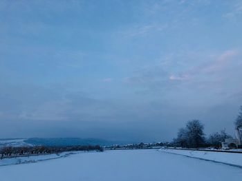 Snow covered landscape against sky