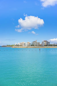 Man doing paddle surfing in the hamakawa fishing port in the chatan city beach in okinawa.