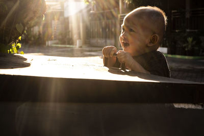 Baby girls saw her old brother playing football in front of our house on sunny day