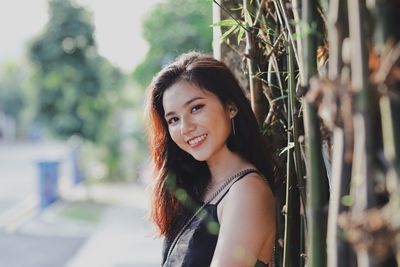 Portrait of smiling young woman standing outdoors