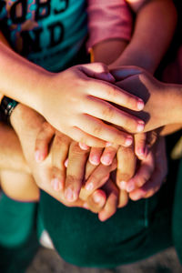 High angle view of friends stacking hands