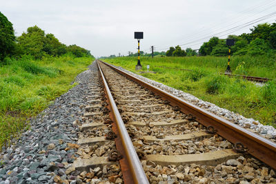 Railroad track amidst trees against sky