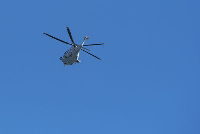 Low angle view of airplane against clear blue sky