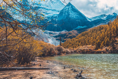 Scenic view of lake by snowcapped mountains during autumn