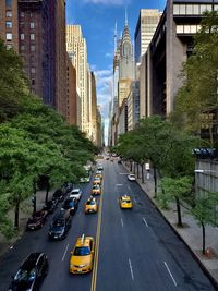 Vehicles on road amidst buildings in city