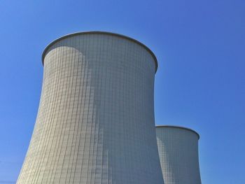 Low angle view of cooling towers against clear sky