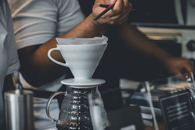 Midsection of man holding coffee cup