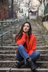 Portrait of young woman sitting on staircase