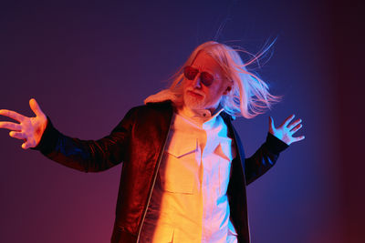 Portrait of woman standing against blue background