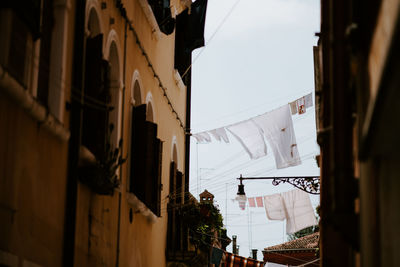 Low angle view of clothes hanging on buildings in city