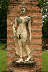 Statue against brick wall