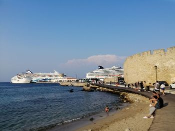 People on beach against clear sky