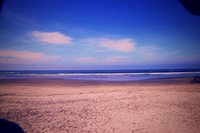 Scenic view of beach against blue sky