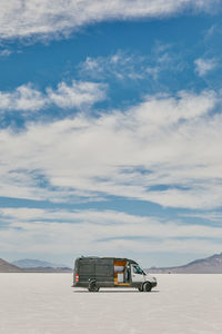 Camper van on bonneville salt flats in utah during a summer road trip.