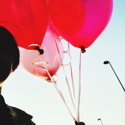 Low angle view of red balloons flying against sky