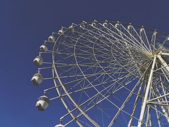 Low angle view of ferris wheel against blue sky