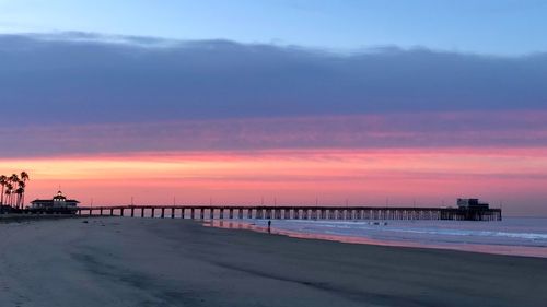 Pier over sea against sky during sunset