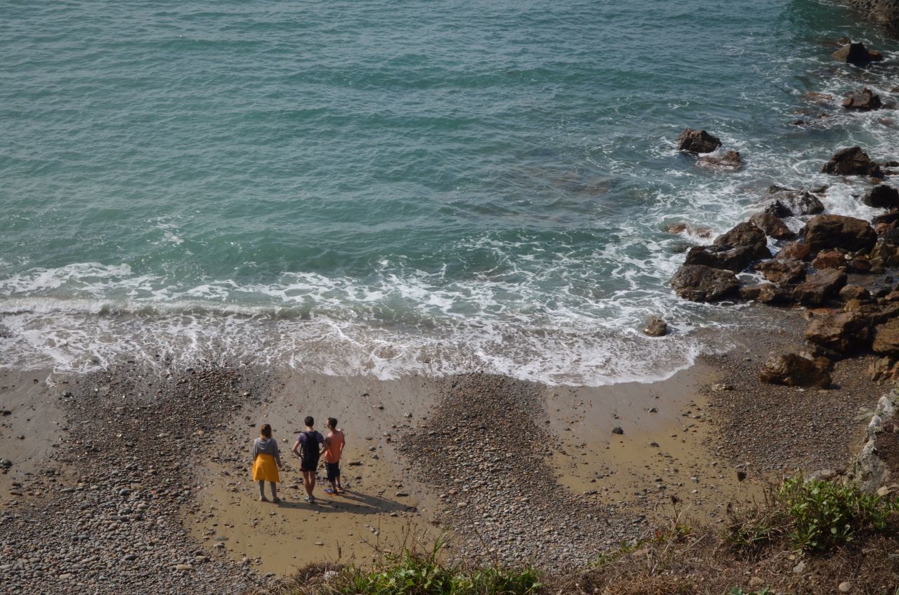 beach, sea, water, shore, high angle view, vacations, surf, sand, coastline, tourist, nature, togetherness, tourism, wave, scenics, travel destinations, beauty in nature, tranquil scene, tranquility, outdoors, non-urban scene, coastal feature, summer, day, tide, seascape