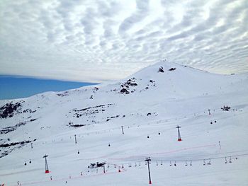 People on snow covered mountain against sky