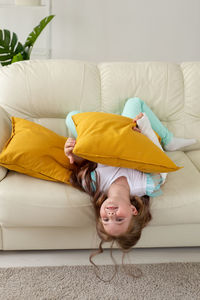 Cute girl lying on sofa at home