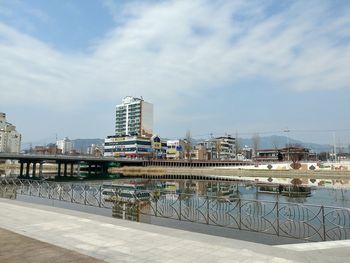 River by swimming pool against buildings in city against sky