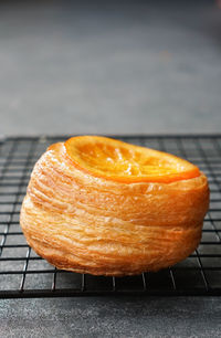 Close-up of puff pastry with candied orange fruit on cooling rack 