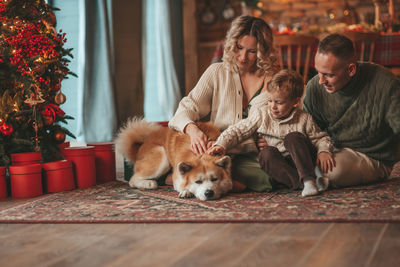 Candid authentic happy family during wintertime together enjoying holidays with dog at xmas