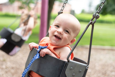 Portrait of smiling boy on swing at playground