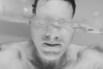 Close-up of shirtless man swimming in pool