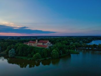 Scenic view of river by buildings against sky