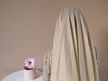 Close-up of white flower vase on table against wall at home