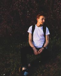 Portrait of young man sitting on field