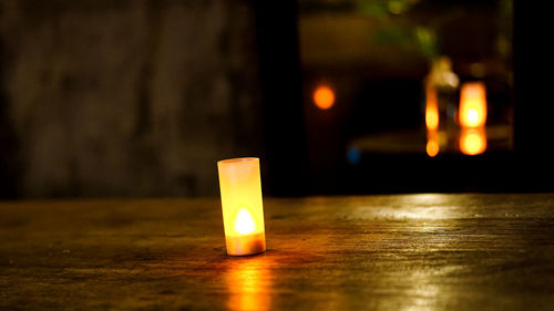 Close-up of illuminated candles on table