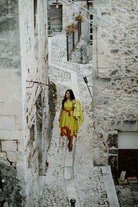 Full length of woman walking on street amidst buildings