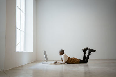 Side view of man using mobile phone while sitting on table