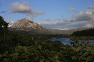 Scenic view of lake and mountains against blue sky