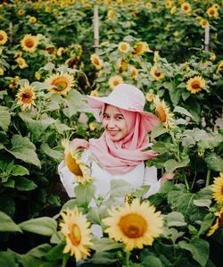 Portrait of woman standing amidst blooming sunflowers