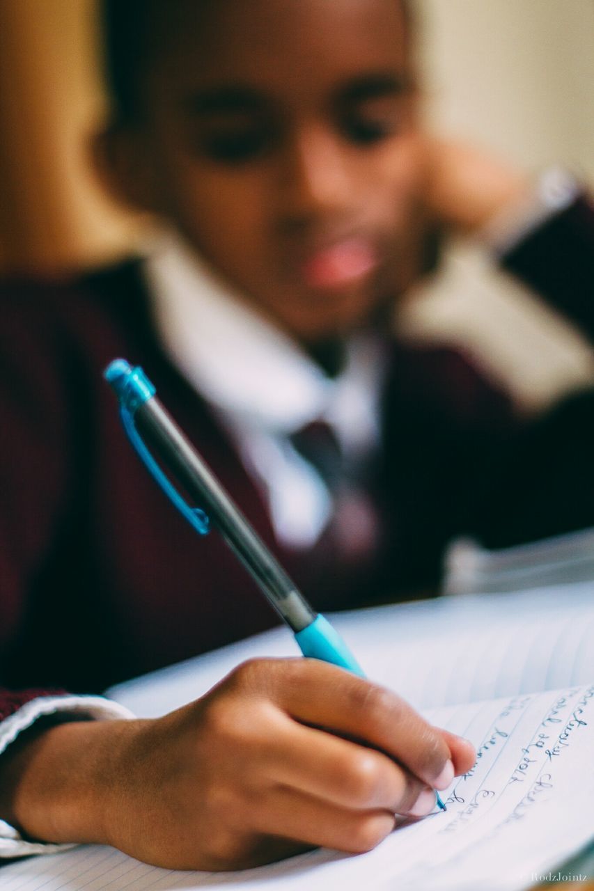 Close-up of boy doing homework at desk