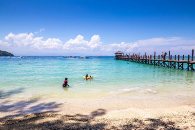 People on beach against sky