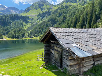 Built structure by lake against buildings and mountains