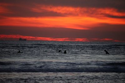 Scenic view of beach against cloudy sky during sunset