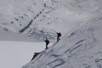 People walking on snowcapped mountain