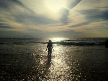 Silhouette man on beach against sky